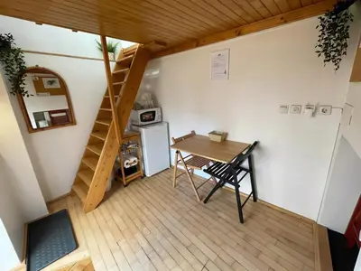 a small room with a table and a staircase at Super Small Micro-Treehouse in the centre in Ljubljana