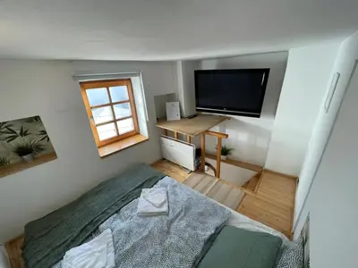 a bedroom with a bed and a flat screen tv at Super Small Micro-Treehouse in the centre in Ljubljana