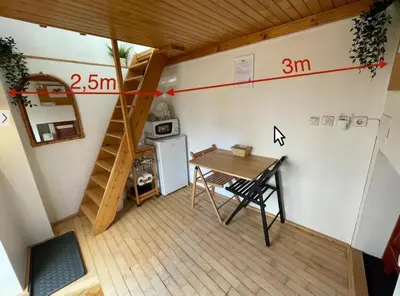 a small room with a table and a staircase at Super Small Micro-Treehouse in the centre in Ljubljana