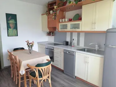 a kitchen with a table and chairs and a sink at Comfy and central with bikes in Bohinj