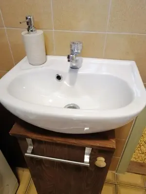 a white sink sitting on a wooden stand in a bathroom at Comfy and central with bikes in Bohinj