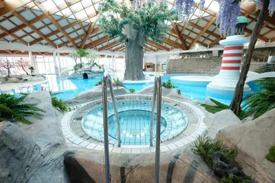 a pool in a resort with a large building at Glamping Terme Čatež in Brežice