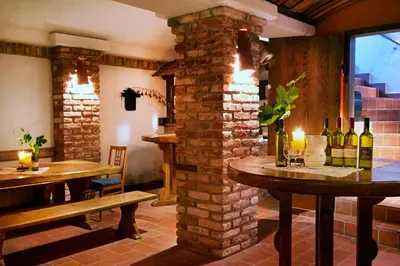 a restaurant with two tables and bottles of wine at Gostišče - Guest house STARI HRAST in Ljutomer