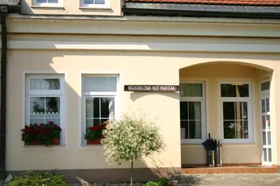 a white building with windows and a sign on it at Gostišče - Guest house STARI HRAST in Ljutomer
