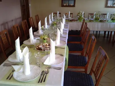 a long table with white plates and candles on it at Gostišče - Guest house STARI HRAST in Ljutomer
