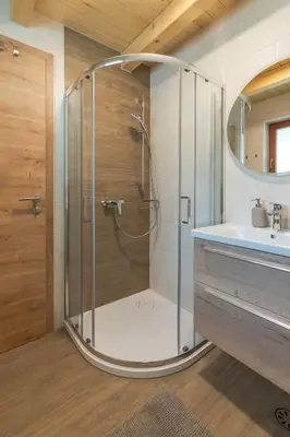 a shower with a glass door in a bathroom at Apartment Orehar in Bohinj