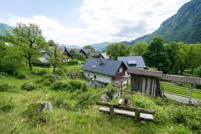 a small village with a bench in a field at Apartment Orehar in Bohinj