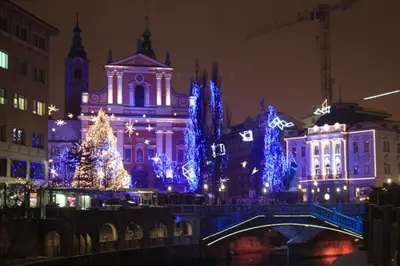 a city lit up with christmas trees and blue lights at Ljubljana apartment in Ljubljana