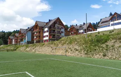 a soccer field on a hill with houses in the background at Stunning Apartment In Pohorje With Wifi in Pohorje