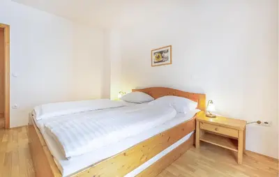a bedroom with a large bed with a wooden headboard at Stunning Apartment In Pohorje With Wifi in Pohorje