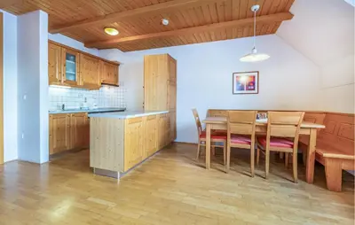 a kitchen and dining room with a wooden table and chairs at Stunning Apartment In Pohorje With Wifi in Pohorje