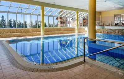 a large swimming pool with blue water in a building at 1 Bedroom Gorgeous Apartment In Pohorje in Pohorje