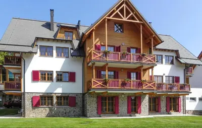 a large wooden house with red doors and windows at Awesome Apartment In Pohorje in Pohorje