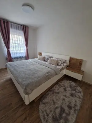 a bedroom with a large bed and a rug at apartma-sobe Lejla in Vipava
