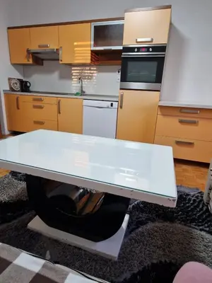 a kitchen with a white table and a stove at apartma-sobe Lejla in Vipava