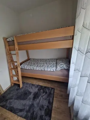 a bedroom with two bunk beds and a rug at apartma-sobe Lejla in Vipava