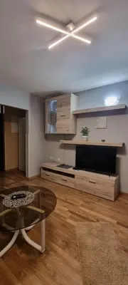 a living room with a ceiling fan and a table at Apartmaji Medved, brezplačno parkiranje in Tacen