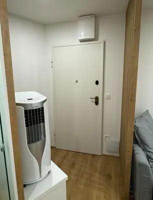 a small room with a white door and a kitchen at Apartma Tisa Bohinj-no outside windows in Bohinj
