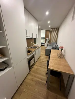 a kitchen and living room with a wooden table in a room at Apartma Tisa Bohinj-no outside windows in Bohinj