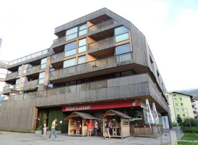 a building with people walking in front of it at Apartma Tisa Bohinj-no outside windows in Bohinj