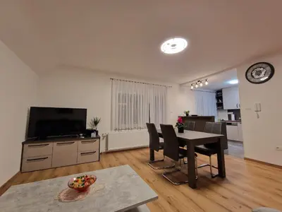 a living room with a dining table and a television at Vila Lastovka in Ljubljana