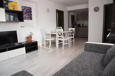 a living room with a table and chairs and a television at Apartma Katja in Škofja Loka