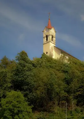 a clock tower on top of a hill with trees at Apartma Katja in Škofja Loka