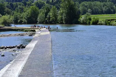 a group of people walking on a bridge over a river at Apartma Katja in Škofja Loka