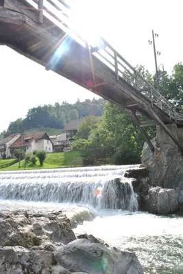 a bridge over a river with a waterfall at Apartma Katja in Škofja Loka