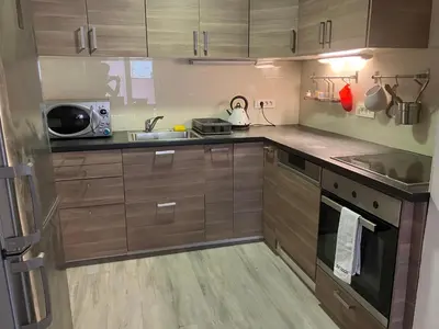 a small kitchen with wooden cabinets and a sink at Apartma Katja in Škofja Loka