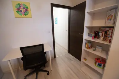 a desk and a chair in a room with a book shelf at Apartma Katja in Škofja Loka