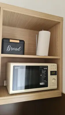 a microwave on a shelf in a kitchen at Apartma Pikabooth in Topolšica