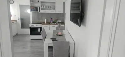 a kitchen with white cabinets and a table with chairs at CILT in Kranj