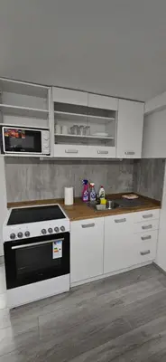 a kitchen with white cabinets and a stove and a sink at CILT in Kranj