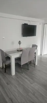 a dining room table with chairs and a television on a wall at CILT in Kranj