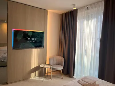 a hotel room with a chair and a window at Tivoli Boutique Inn in Ljubljana