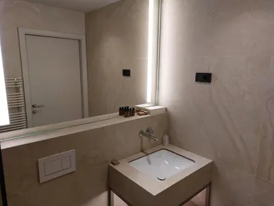 a bathroom with a sink and a mirror at Tivoli Boutique Inn in Ljubljana