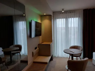 a hotel room with two tables and a tv at Tivoli Boutique Inn in Ljubljana