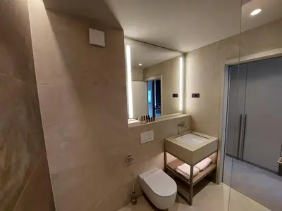 a bathroom with a toilet and a sink and a mirror at Tivoli Boutique Inn in Ljubljana