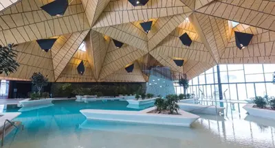 a large building with a swimming pool with a ceiling at Terme Olimia - Apartment 407 in Podčetrtek