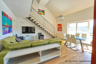 a living room with a green couch and a table at Terme Olimia - Apartment 407 in Podčetrtek