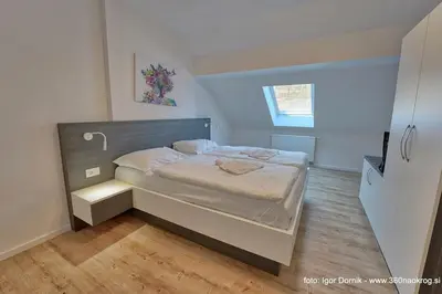 a bedroom with a bed with a wooden floor at Terme Olimia - Apartment 407 in Podčetrtek