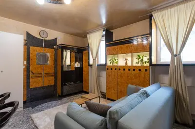 a living room with a blue couch and a television at Apartments Perla in Krško