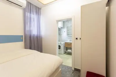 a bedroom with a bed and a bathroom at Apartments Perla in Krško
