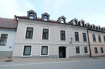a white building with many windows on a street at Apartments Perla in Krško