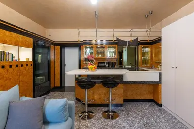 a kitchen with a counter and a sink and a couch at Apartments Perla in Krško