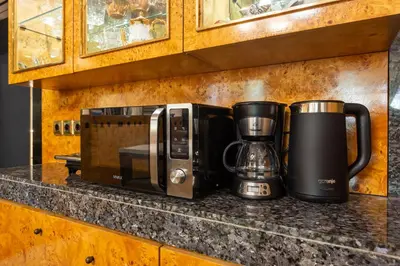 two coffee cups sitting on a counter next to a microwave at Apartments Perla in Krško