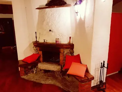 a living room with a brick fireplace with red pillows at Under The Castle Apartments Ljubljana in Ljubljana