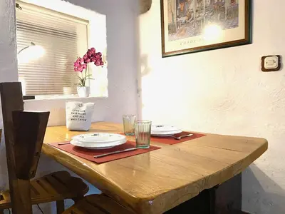 a wooden table with plates and glasses on it at Under The Castle Apartments Ljubljana in Ljubljana