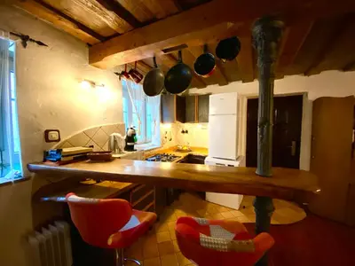 a kitchen with a counter with red chairs in it at Under The Castle Apartments Ljubljana in Ljubljana